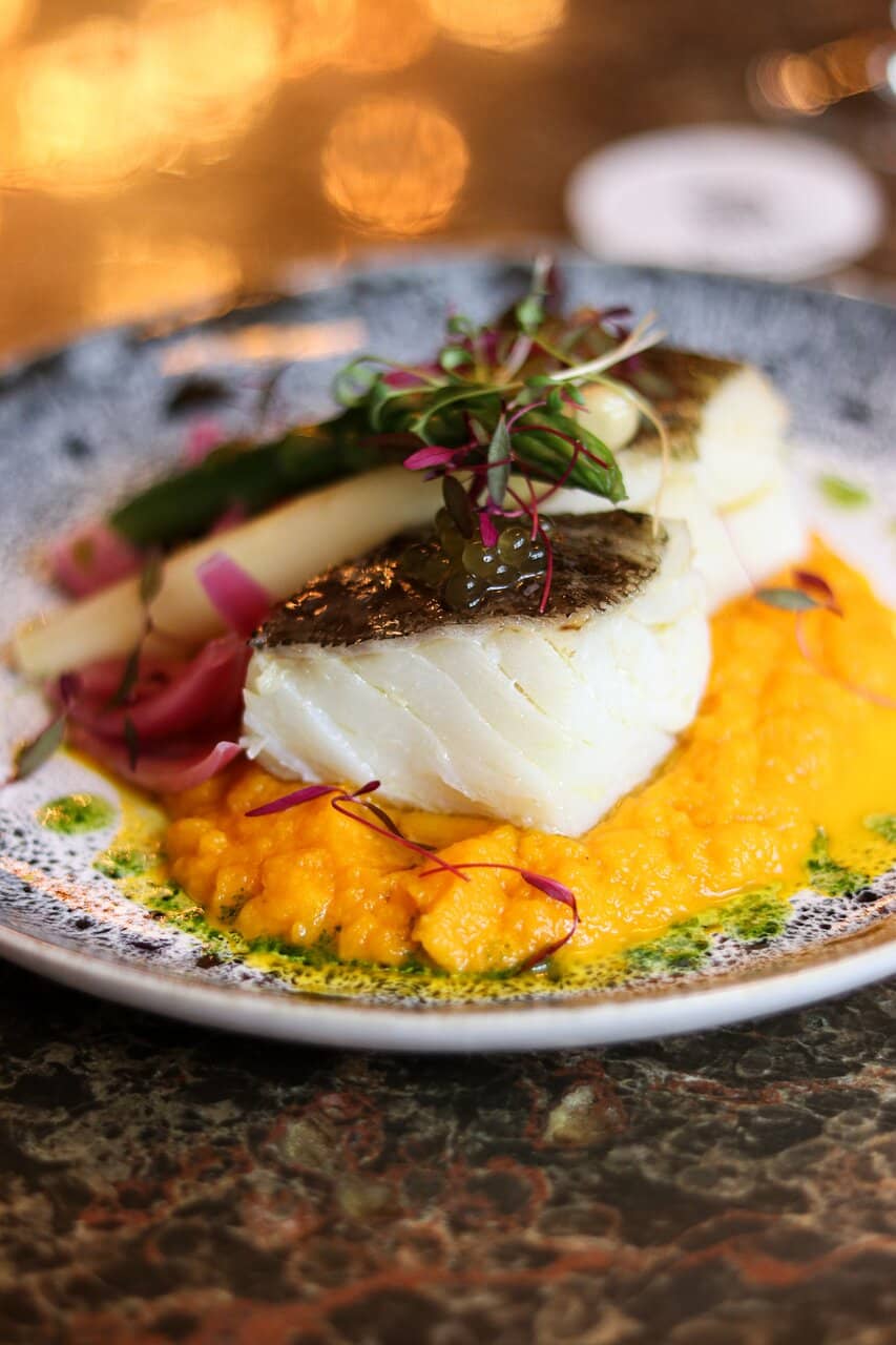 Bacalhau confitado com Puré de Cítricos, Espargos e Pickles de Cebola Roxa