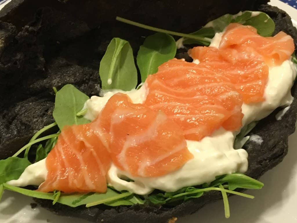 Panzerotto al nero di seppia con salmone, stracciatella, rucola e olio evo agli agrumi