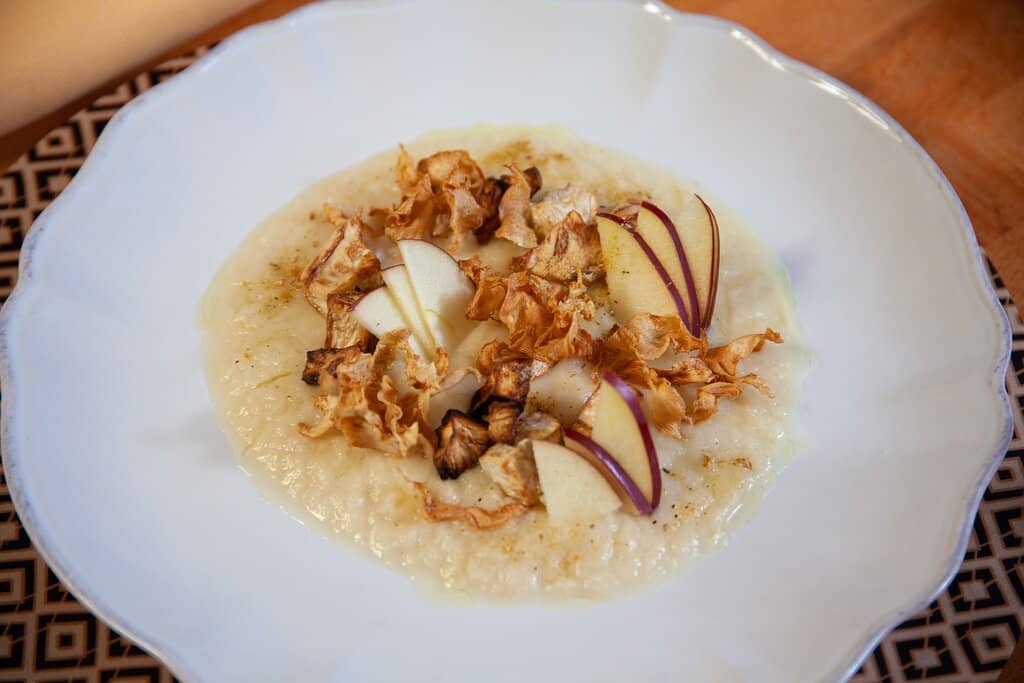 Agnello con salsa di acciughe, sedano rapa e carciofi croccanti