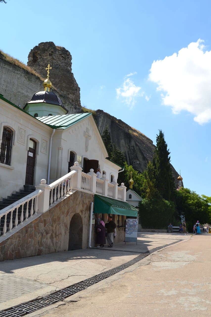 Здание церковной постройки, возведенной на старом фундаменте (вверху на скале развалины крепости Каламита).
