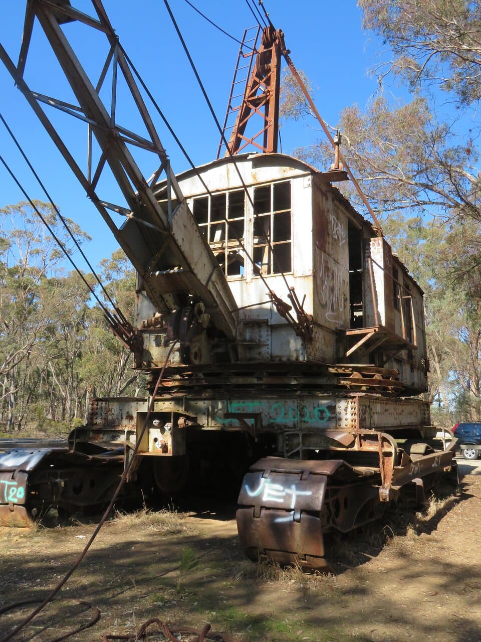 Front section of the dragline excavator; note the crawler tracks, the boom/jib fixed into the chassis and the wire ropes for controlling the bucket and boom. 