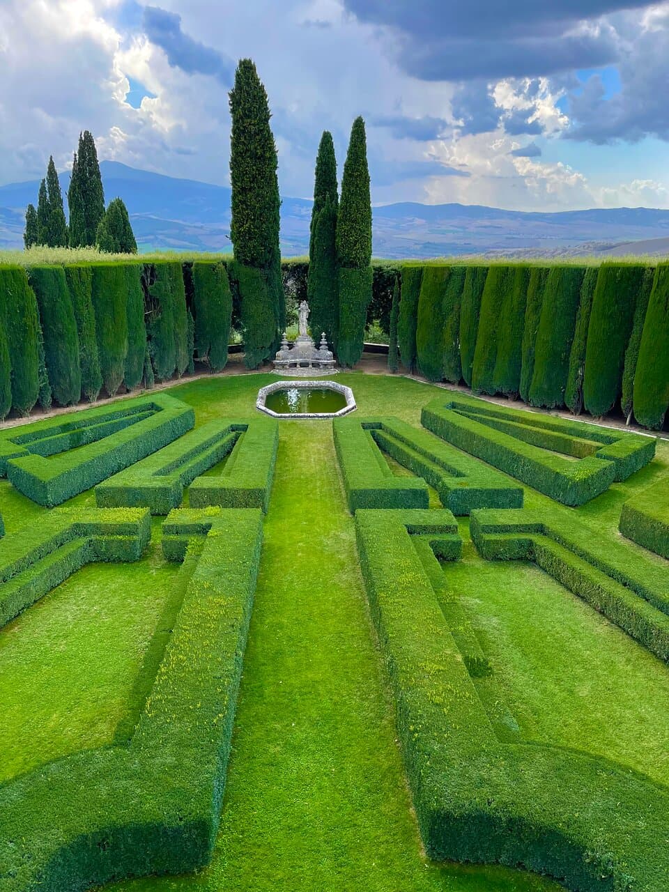 This formal lower section of the garden was completed in 1939, just before the war. Double box hedges underline its geometric forms that lead to a low travertine pond.