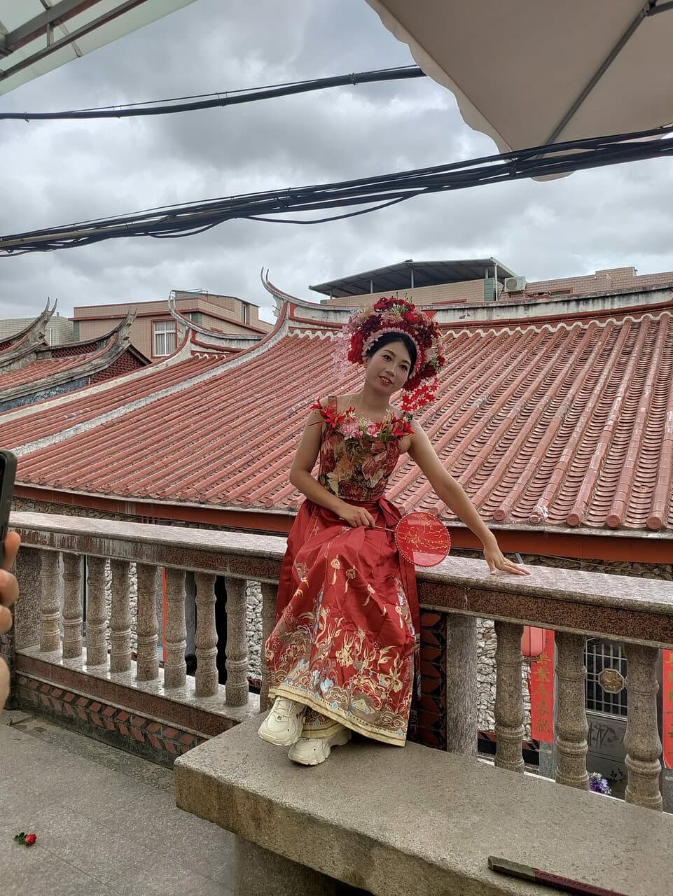 A young girl adorned with the typical Xunpu flower garland, posing for a photoshoot.