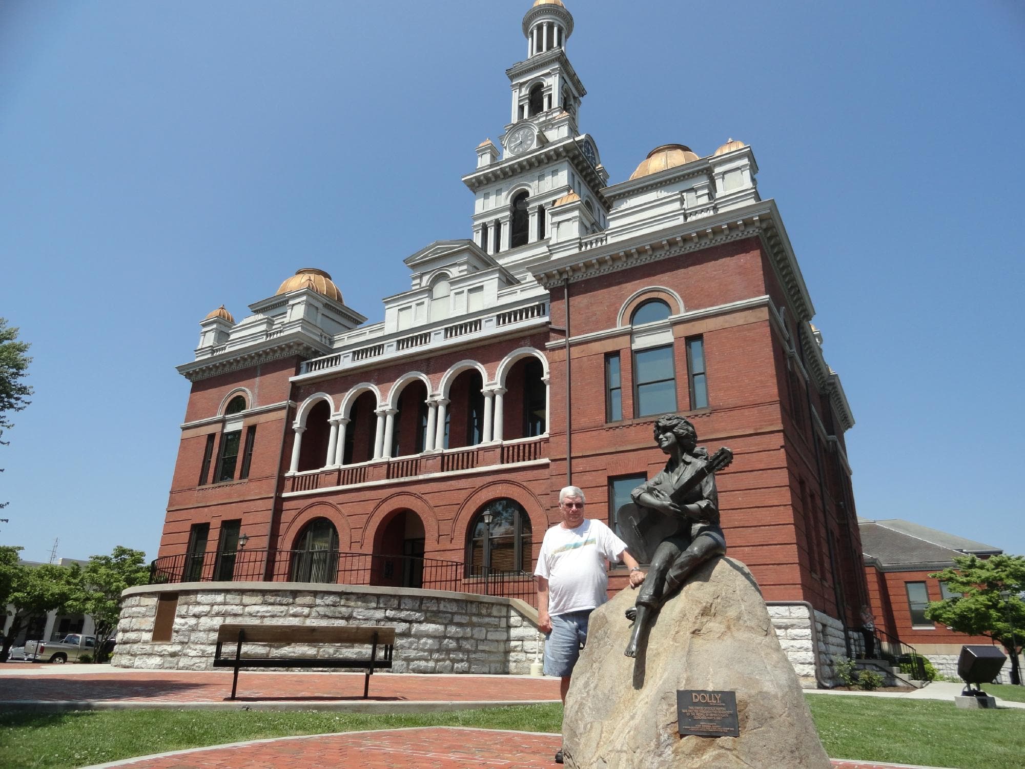 The statue sits on the lawn of the city building.
