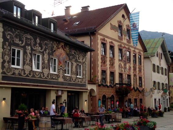 White building on left with green roof.