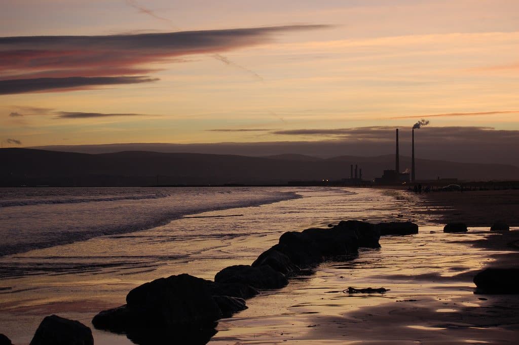Solnedgang set fra den østlige del af stranden tilbage mod the bull wall og Dublin havn