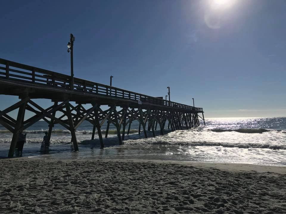 sun coming up over the pier