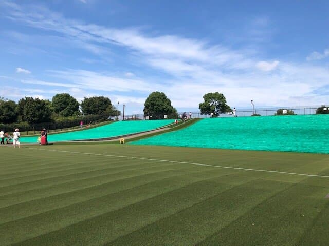 《舎人公園》「ソリゲレンデ」:無料で芝滑りを楽しむことが出来るソリ専用の人工芝ゲレンデです。子供たちの活き活きした笑顔が見られます。一回滑ると病み付きになるらしく何回も挑戦している子供もいました。小さい子供たちはお父さんやお母さんと一緒に滑っていました。「ソリゲレンデ」のコースは斜度16度の「初心者コース」と斜度20度の「上級者コース」に分かれています。