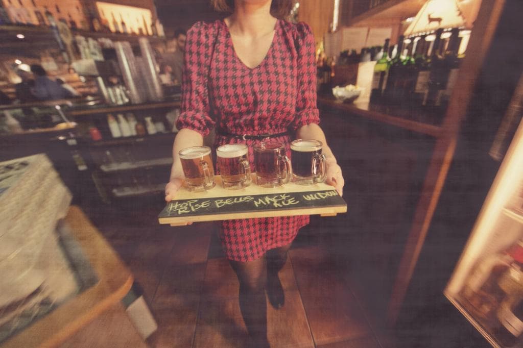 Amber serving a beer flight