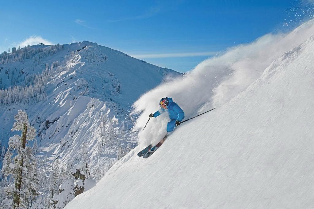 Olympian & resort ambassador Daroh Rahlves skiing with the famed Palisades behind him