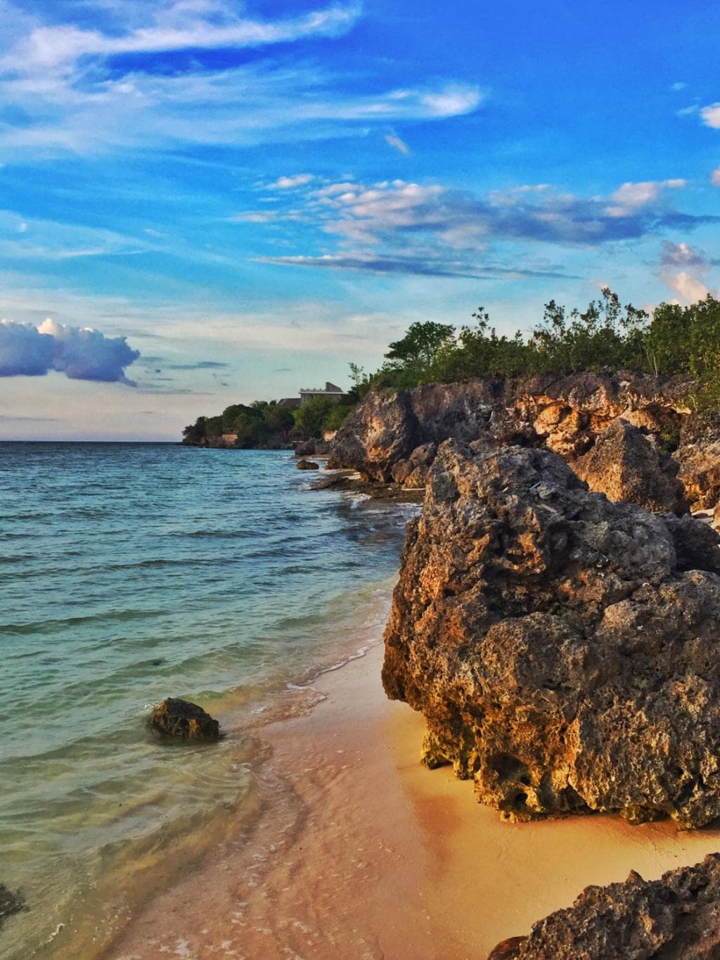 The hidden stretch of beach beyond the rocky outcrop