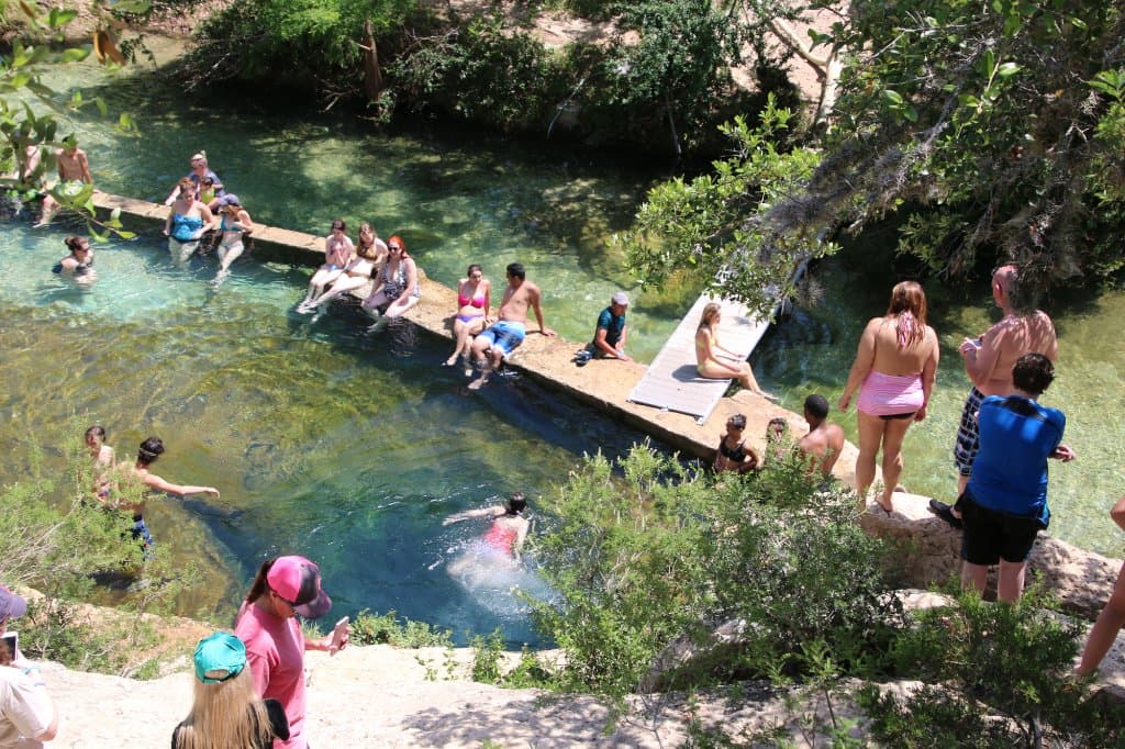 Teens and college age jump off the rocks