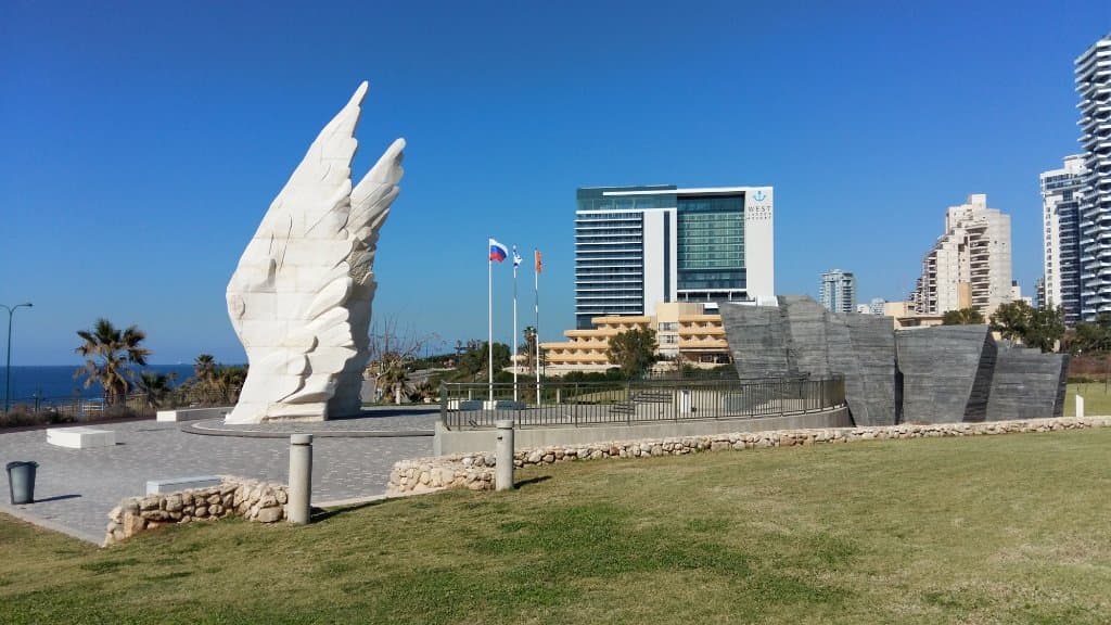 White wings, black war memories and blue sky near the sea