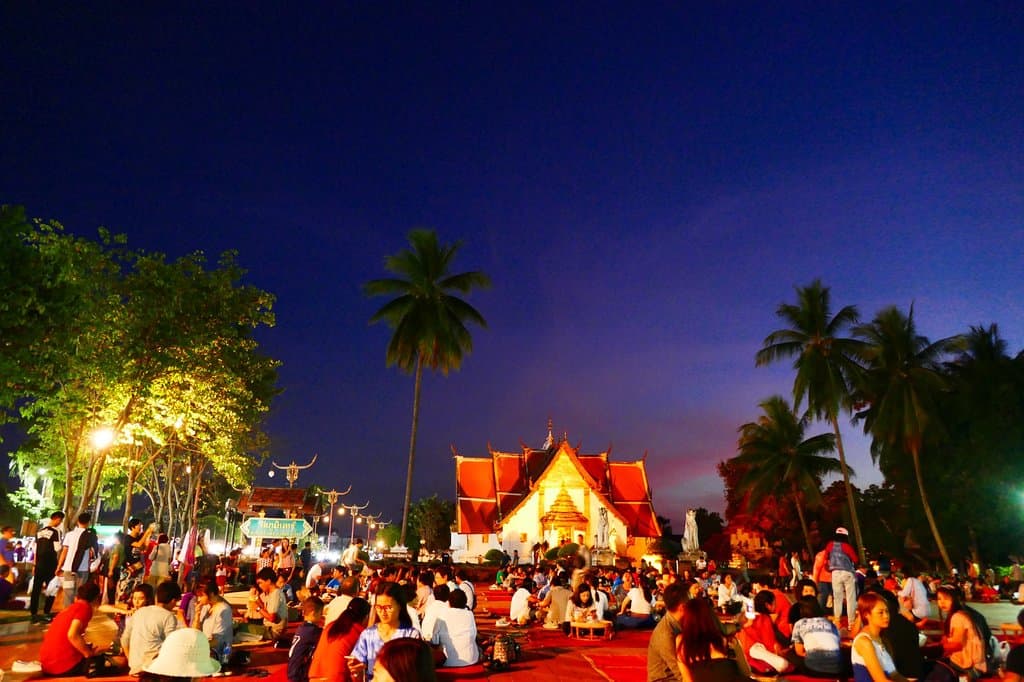 Enjoying street food in the town square with Wat Phumin in the background