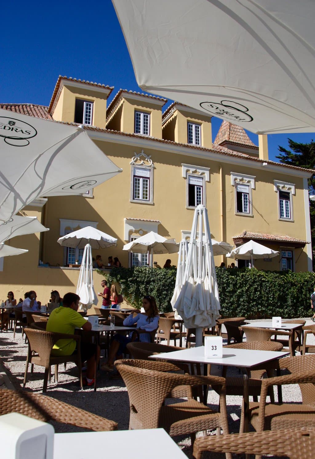 In de zon of onder de parasol op terras aan de oceaan