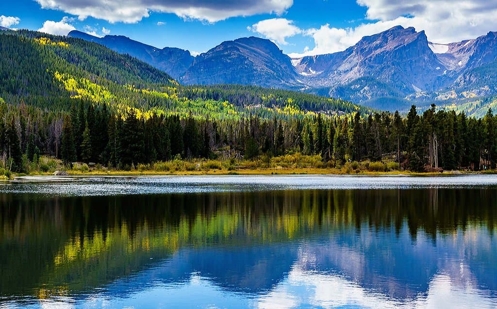 Get up early to watch the sunrise from Sprague Lake on the west side of Rocky Mountain National Park. This small man-made lake inside the park has a short walking trail along the water's edge. There in midday? Get your waders and fishing pole in Estes Park and go fishing here. PC: Adobe Stock . #Fishing #FamilyAdventures #NationalParks #ADA #LakesidePicnic #EasyHikes