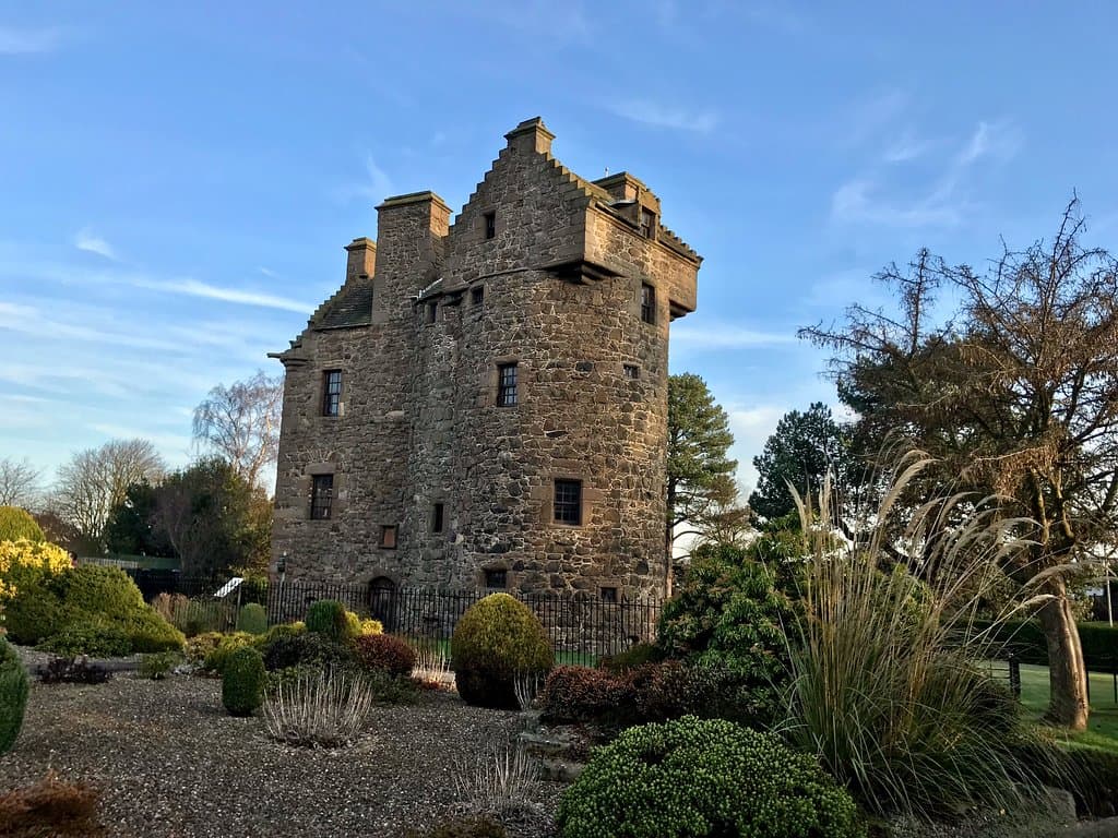 Claypotts Castle with a neighbouring private garden in the foreground