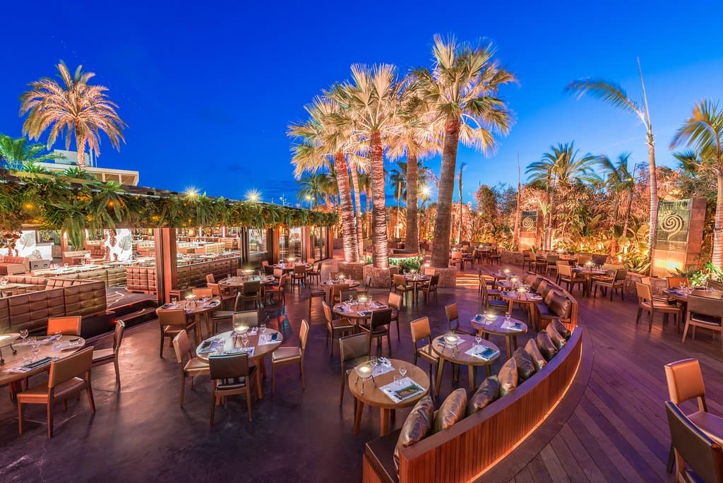 Une partie de la terrasse fleurie et tropicale de notre restaurant, à la tombée de la nuit. 