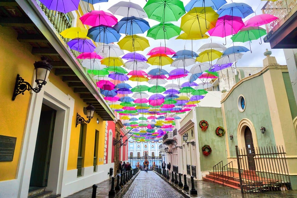 Colorful umbrellas floating above the historic buildings on Calle Fortaleza.