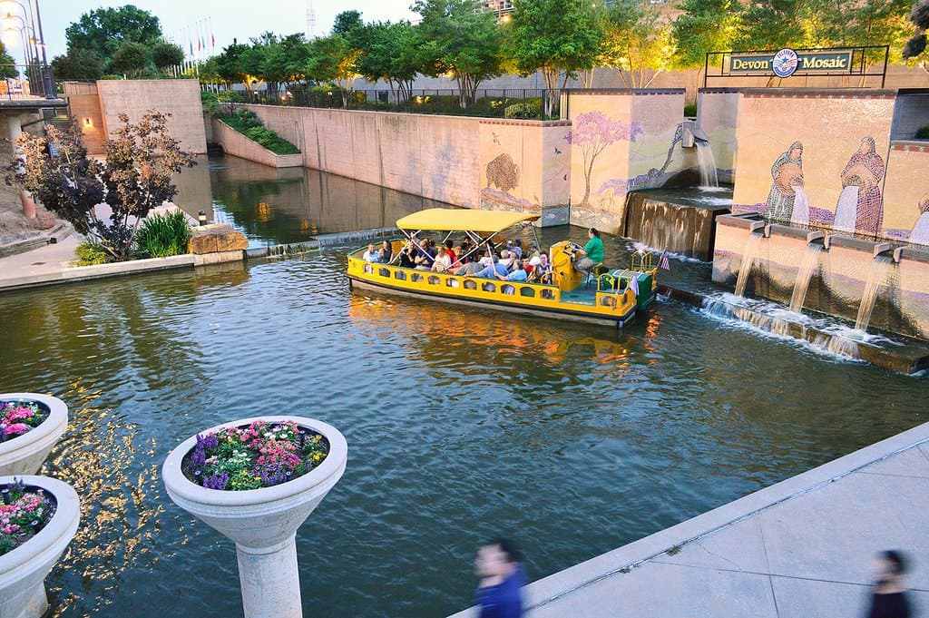 A Water Taxi turning around in the Bricktown Canal's western terminus, in front of the Devon Mosaic.