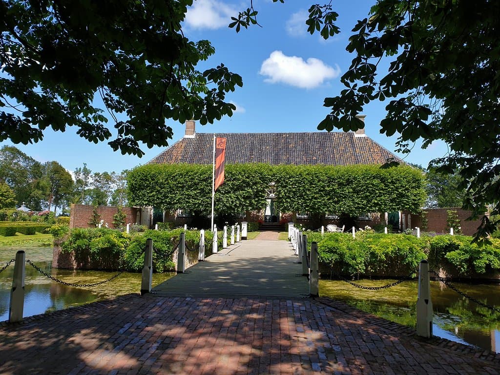 De entree van de Borg ligt verscholen achter een bomenrij.
