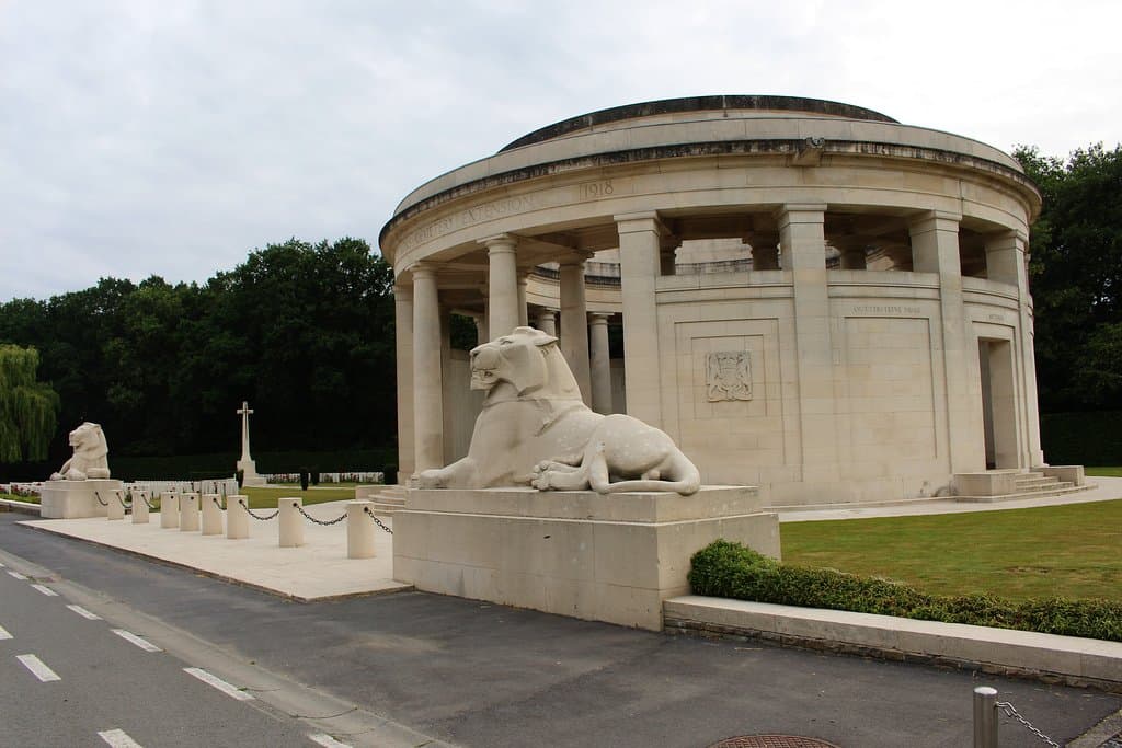 vista del monumento al completo con la cruz de sacrificio del cementerio al fondo