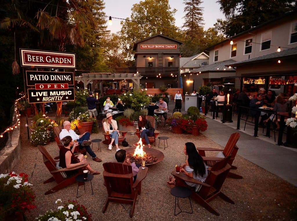 Guest enjoying the fire pit at the entrance to our 150 seat patio on the Napa River