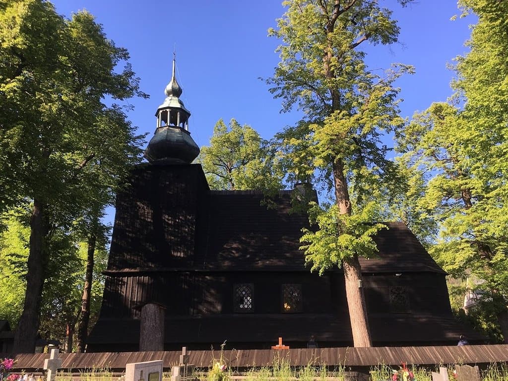 Wooden church from 1690. Zabytkowy 330-letni kościółek z drewna modrzewiowego wśród zieleni.