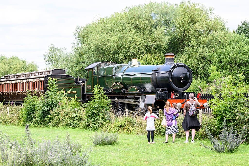 Enthusiastic visitors watch locomotive 2999 "Lady of Legend" and a train of magnificently restored vintage carriages at Didcot Railway Centre
