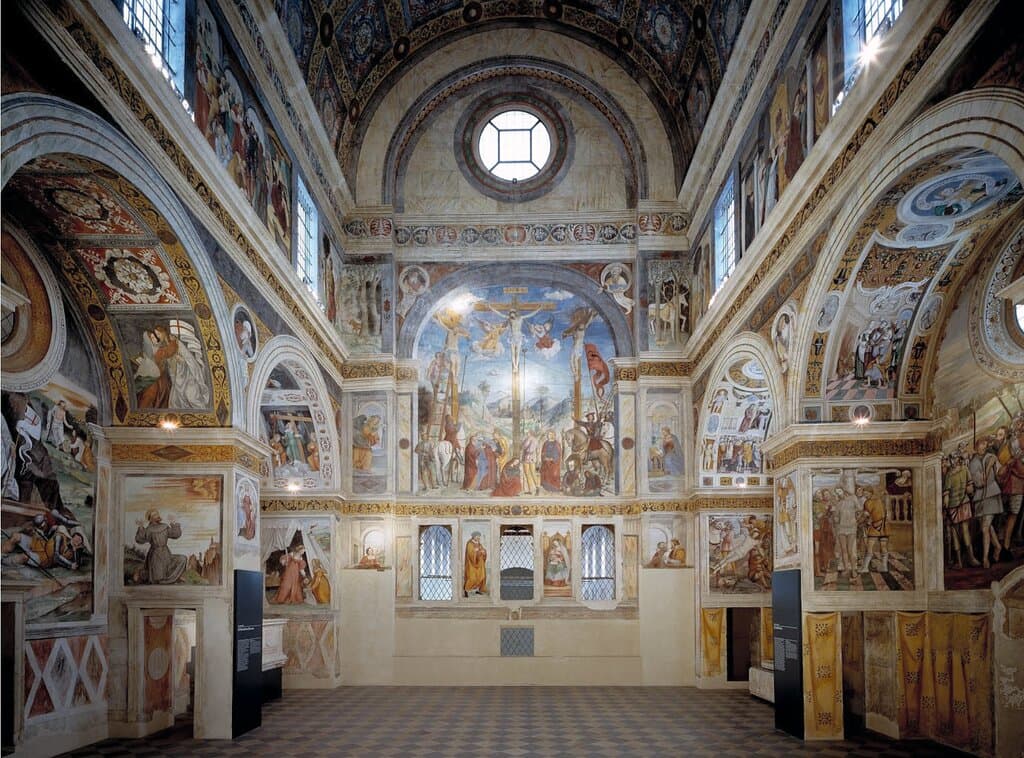 Coro delle monache (Metà XV secolo d.C.)

Il coro permetteva alle monache di clausura di seguire le funzioni religiose che si tenevano nella Basilica di San Salvatore. Le pareti vennero interamente affrescate, secondo un tema iconografico ispirato al tema della salvezza e realizzato da artisti diversi, in un periodo di tempo compreso tra il terzo e il sesto decennio del XVI secolo.
