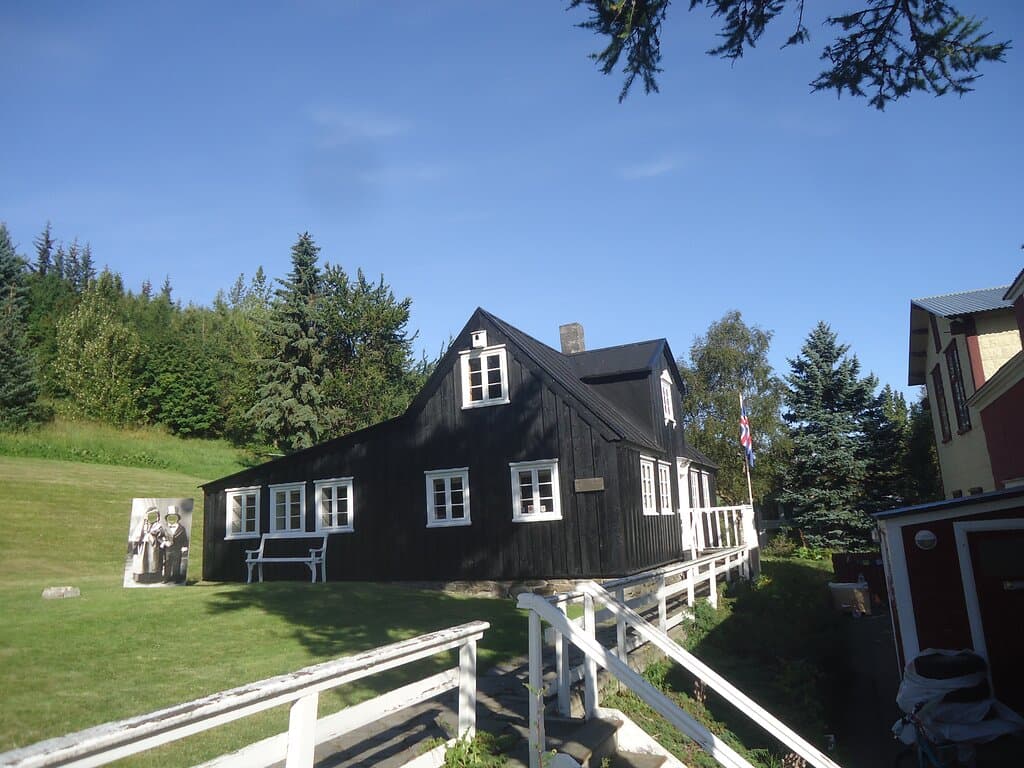 Czarny drewniany budynek z białą stolarką wyróżnia się między typowymi i najczęściej kolorowymi dziś domami .