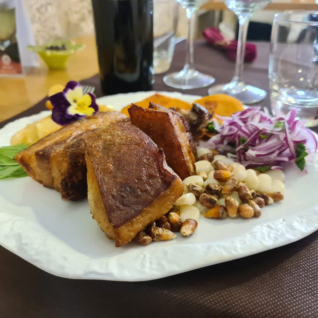 Chicharrón de cerdo al estilo Perú acompañado de camote frito
(boniato) yuca fritas canchita chulpi choclo y cebolla roja en sarza.