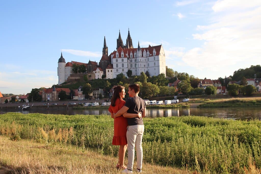 Pärchen am Ufer der Elbe mit Blick auf die Albrechtsburg Meißen. ©DieWeltgeniesser