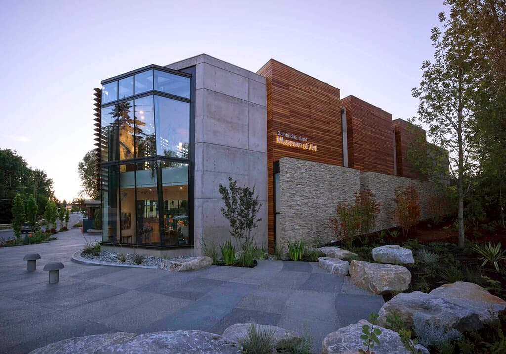 Bainbridge Island Museum of Art’s striking building was designed by Matthew Coates of Coates Design Architects. The 20,000 square foot building—with space to host exhibitions and educational programs for audiences of all ages, interests and skill levels—provides a place to celebrate the art and artists of the Puget Sound region. The Museum opened on June 14th, 2013 and received Leadership in Energy and Environmental Design (LEED) Gold status in late 2016.

