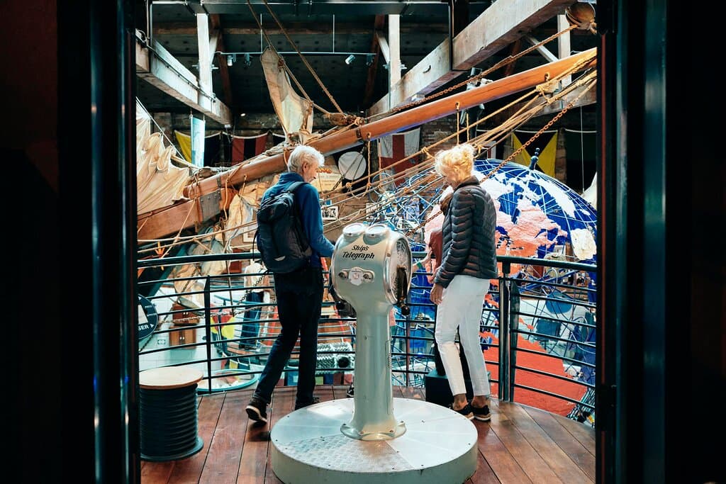 Couple stand on bridge overlooking the Globe Room at the Maritime Museum