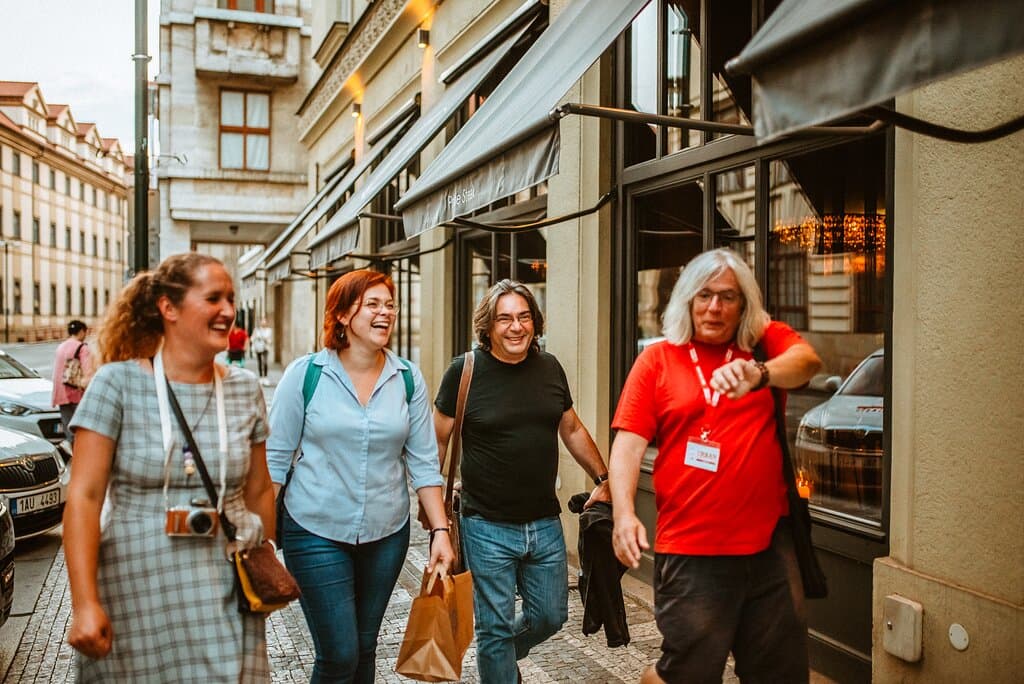 Guide making a group laugh while walking the streets of Old Town in Prague