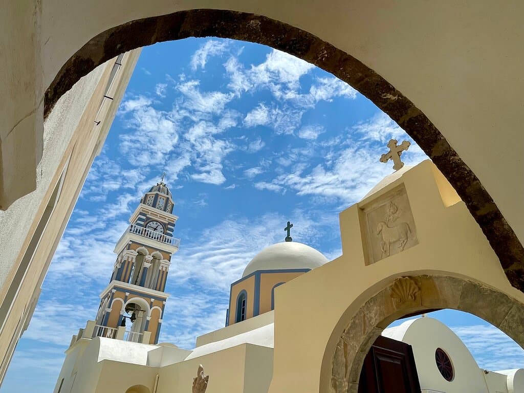 The colourful, Baroque bell tower and dome of St John the Baptist Cathedral, in Fira.