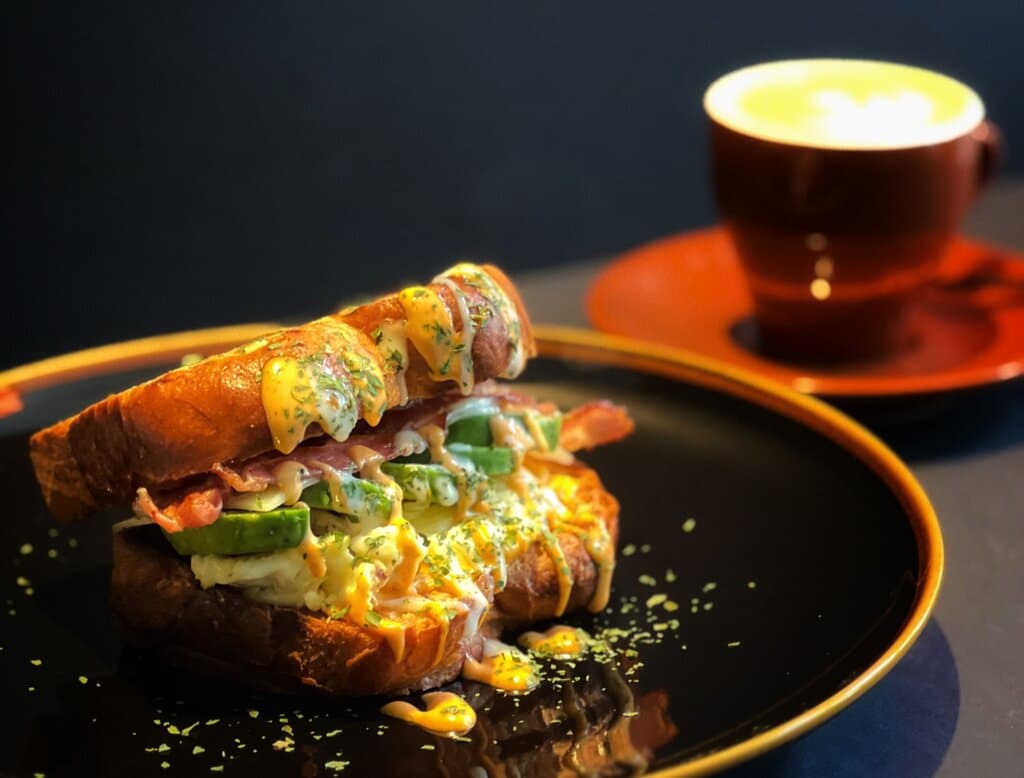 Dieses Frühstückssandwich wurde von einem Café in Südkorea namens Egg Drop entwickelt. Und jetzt bringt YONG YONG dieses köstliche Sandwich nach Trier! Danke an unsere Freundin Kathrin für diesen leckeren Tipp.  Zauberhaft serviert in geröstetem Brioche, lockerem Rührei, Avocado, Bacon, Käse und genialer Saucen.