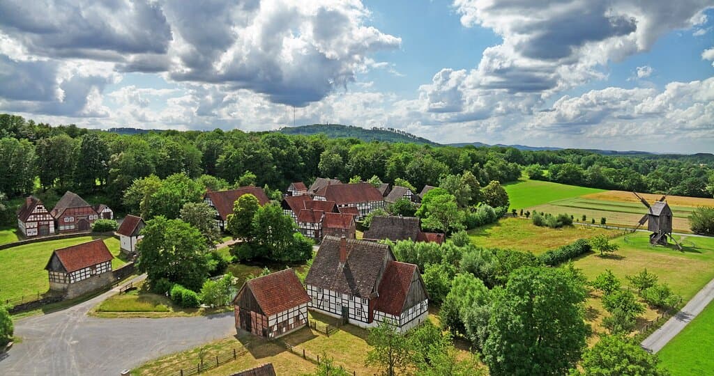Einzigartiger Blick voller Sonnenstraheln über das Paderborner Dorf samt Bockwindmühle.