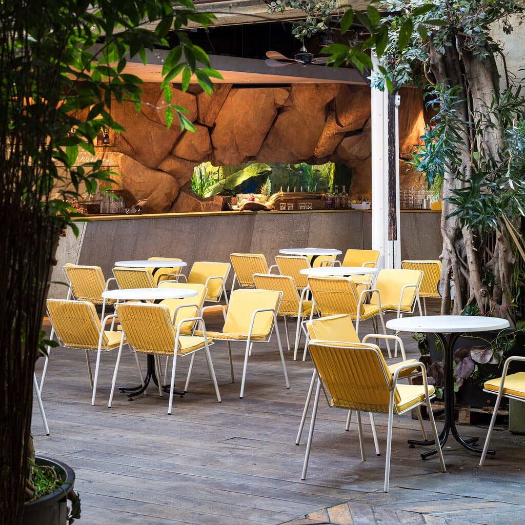 La salle de l'aquarium au Comptoir Général est baigné de lumière naturelle grâce à ses puits de lumière. Entouré de fenêtres et de portes vitrées, il offre une vue relaxante sur le jardin environnant. Cet espace enchanteur crée une atmosphère apaisante, invitant les visiteurs à profiter de notre cuisine de la mer tout en sirotant leurs cocktails.