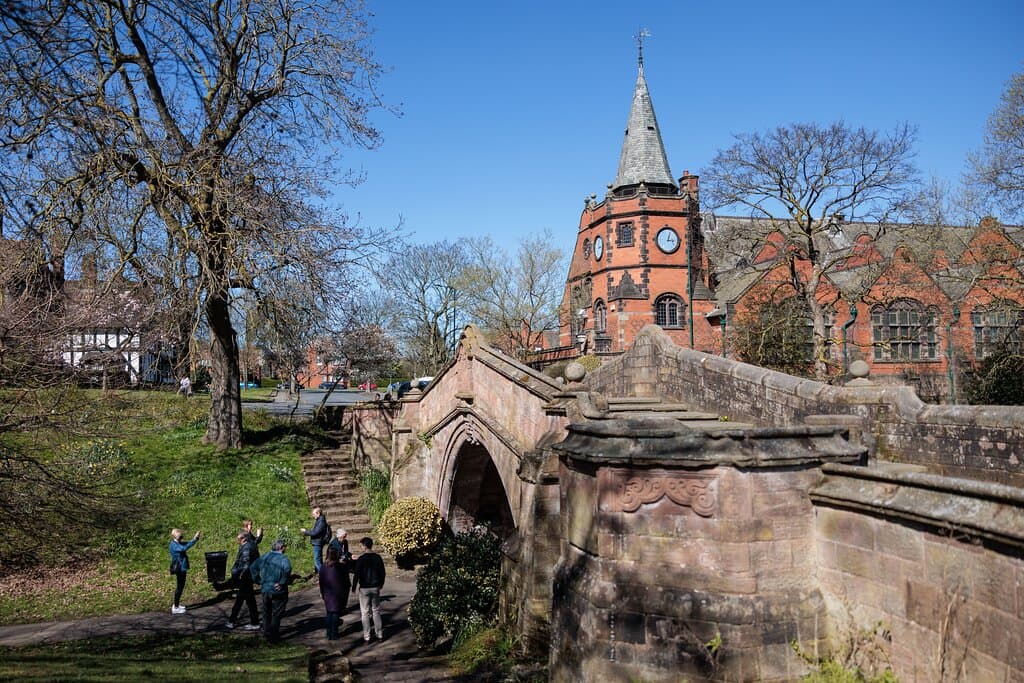 A group of visitors on a walking tour of Port Sunlight, underneath the Dell Bridge.