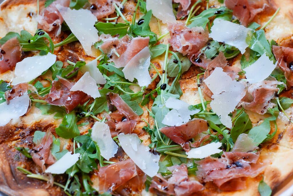 Prosciutto di Parma and Parmigiano Reggiano flat bread with arugula, fresh mozzarella, aged balsamic and extra virgin olive oil