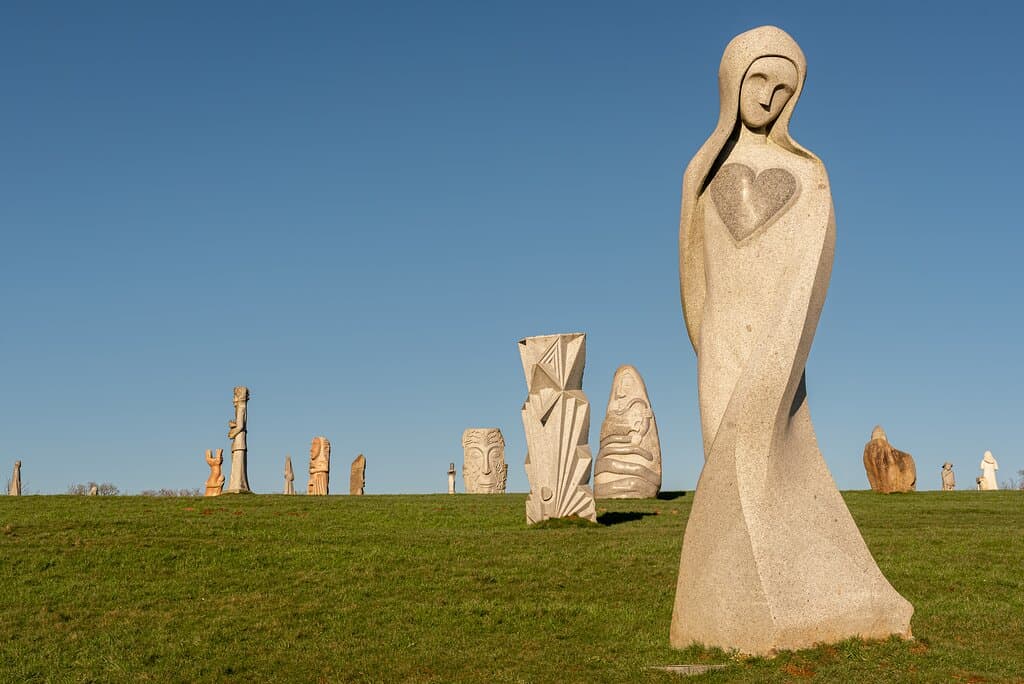 St Bleuen sculpté par Christophe, une statues avec un cœur sur l  avec plusieurs statues derrière