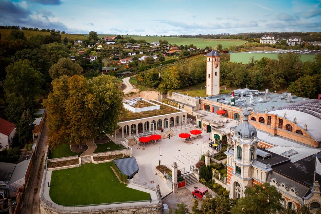Blick auf das Gelände der Rotkäppchen Erlebniswelt, umgeben von den Weinbergen und der Landschaft Freyburgs.