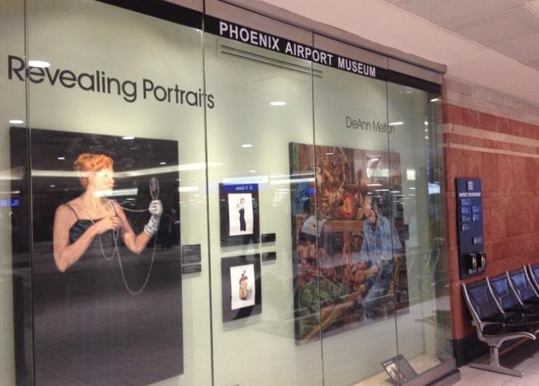 Here a glass display case pokes into the airport, showing an exhibition of portraits.