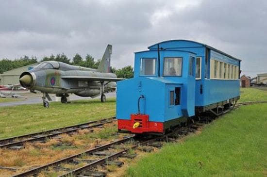 Saturday train passing English Electric Lightning jet aircraft parked on Skegness Airfield.