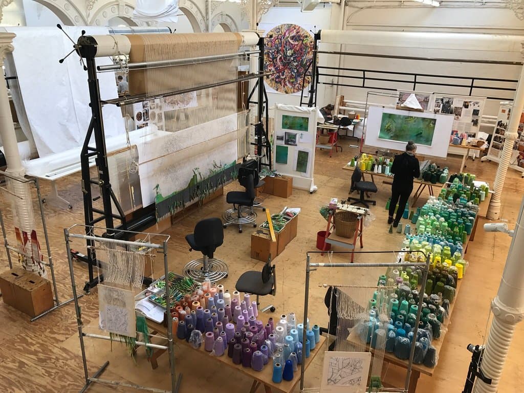 View of the workroom from the mezzanine area where visitors can watch the weavers at work.