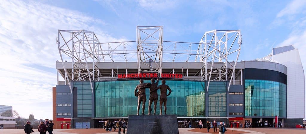 Old Trafford featuring the Trinity statue outside of the East Stand