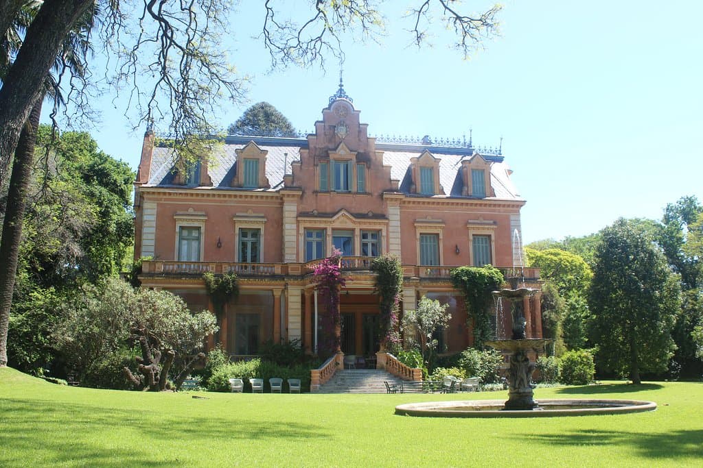 La casa vista de frente se ubica en el centro de los jardines.