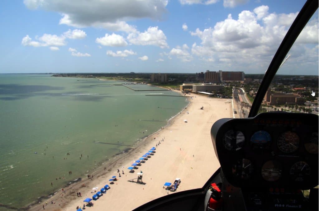 View of McGee Beach from helicopter during the summer. The blue cabanas for rent add to the ambiance.